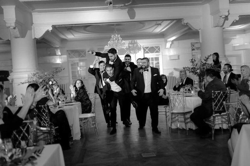 The groom carried in on his groomsmen's backs, making their entrance through the reception at a Montréal wedding