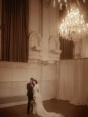 The couple together beneath a crystal chandelier in a historic Montréal ballroom